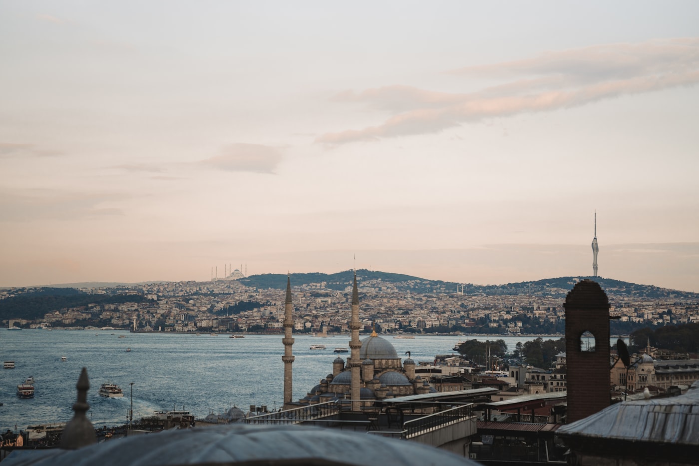 The Istanbul skyline at dusk, with mosque domes and minarets above the Bosphorus strait.
